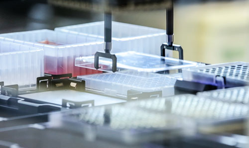 A machine picks up a tray of liquid samples.