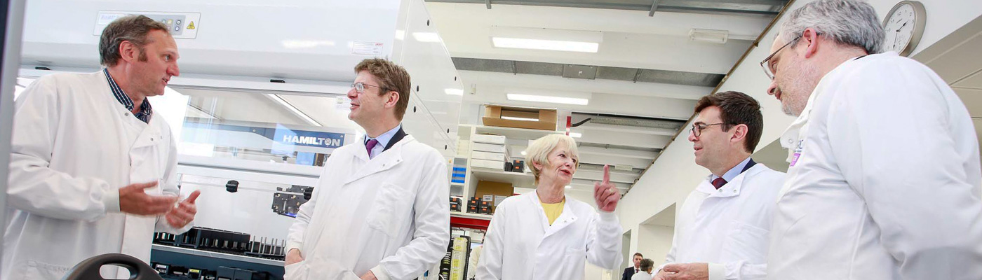 A group of scientists stand chatting in a group.