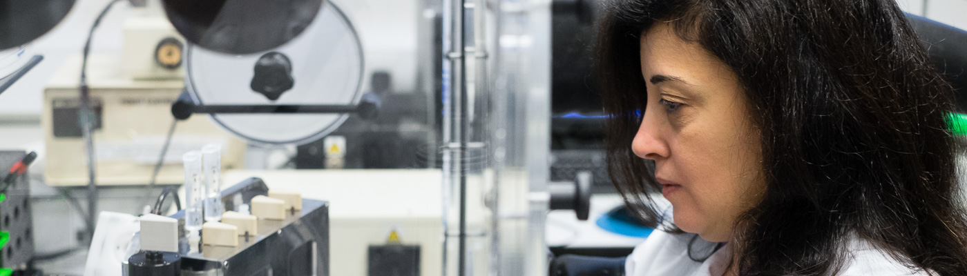 A female scientist works at a fume cupboard, with her hands in gloves that are built in.