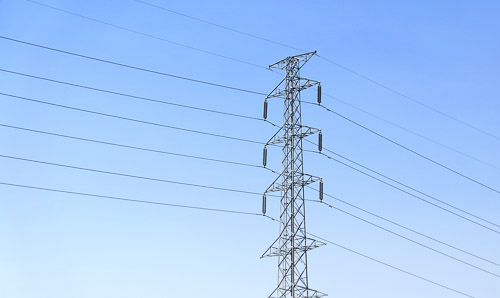 An electricity pylon against a blue sky.