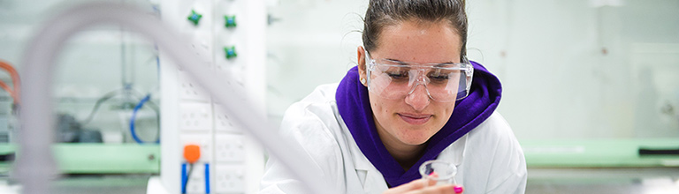 Female student in a lab looking at a test-tube