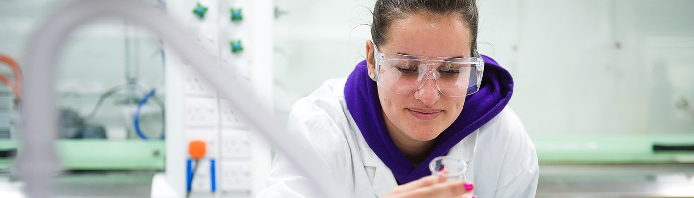 Female student in a lab looking at a test-tube